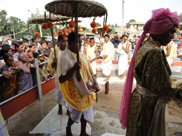 Man standing with umbrella during Kharchi Puja
